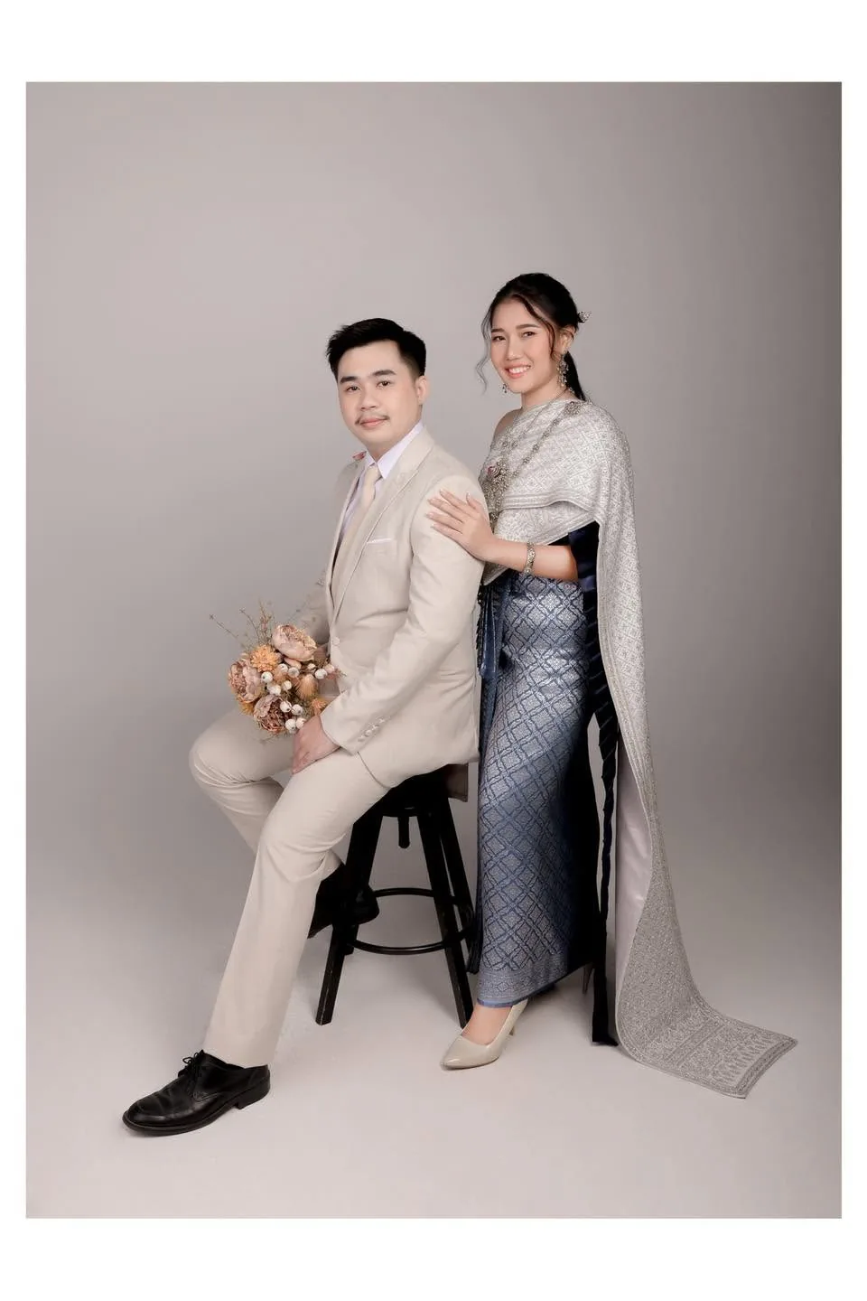 คู่บ่าวสาวในชุดไทยนั่งและยืนคู่กันในสตูดิโอ