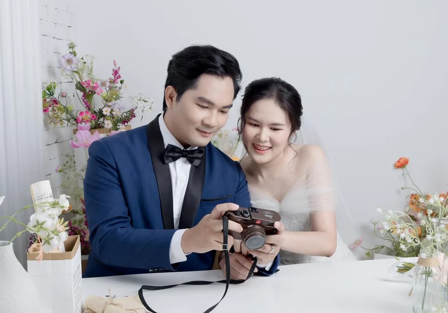คู่บ่าวสาวในชุดแต่งงานนั่งดูภาพจากกล้องด้วยกัน